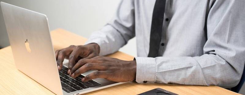 Professional looking at laptop – ICT Expert role at Noo Wangoko Foundation